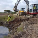 Excavating Japanese Knotweed near water in Bristol, Somerset